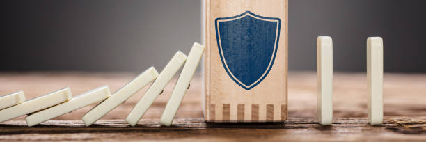 istock Block With Shield Symbol Amidst Falling Domino Pieces 1429980086