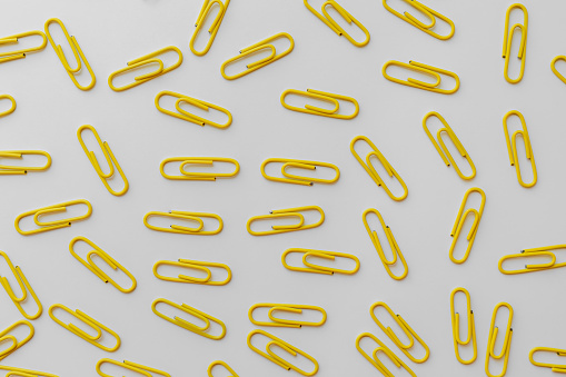 Yellow paper clips on paper on table