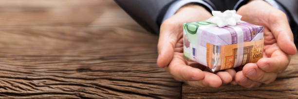istock Businessman Holding Gift Box Made From Euro Papernotes 1429981160
