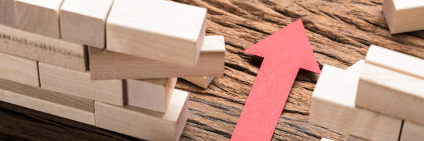 istock Red Paper Arrow Amidst Blocks On Wooden Table 1429981197