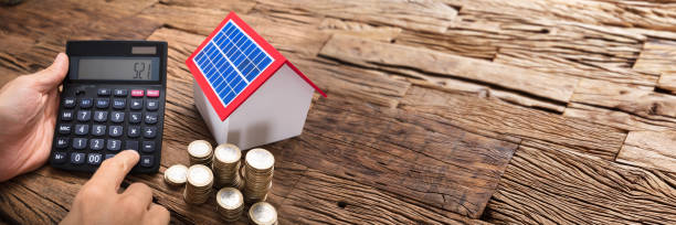 istock Businessman Using Calculator By Coins And Solar Model Home 1429981201