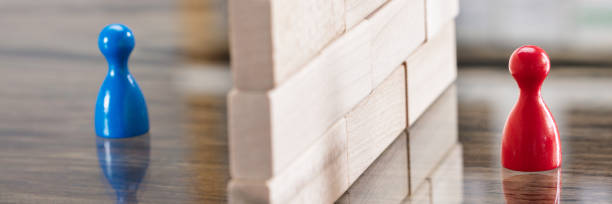 istock Red And Blue Figurine Paw Separated By Wooden Blocks 1429981221