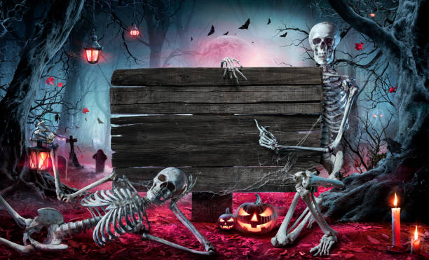 Halloween Card In Forest With Wooden Sign Board - Graveyard At Night With Pumpkins And Skeletons stock photo