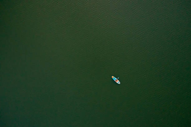 istock Drone point view of young man, lying on a standup paddleboard 1429985438