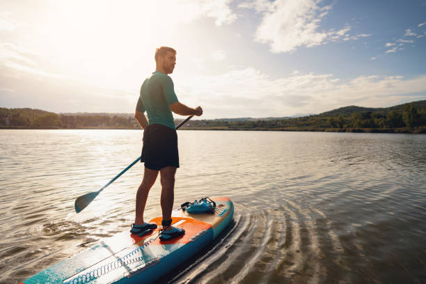istock Young man, paddleboarding with standup paddleboard on a lake 1429986384