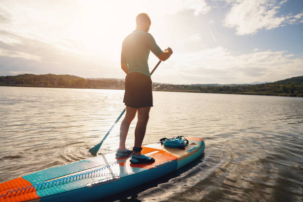 istock Young man, paddleboarding with standup paddleboard on a lake 1429986430