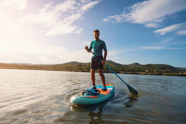 istock Active young man, paddleboarding with standup paddleboard on a lake 1429986441