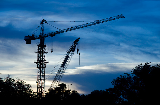 Construction crane silhouette  in blue sky at sunset, Bangkok Thailand.