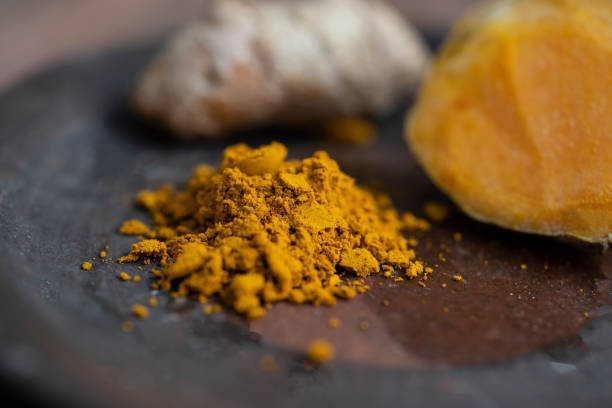 istock Yellow turmeric powder in black plate. 1429996017
