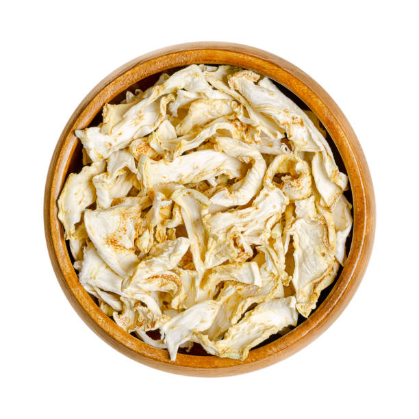 Celery root, celeriac, dehydrated slices, in a wooden bowl Celery root, dehydrated slices, in a wooden bowl. Celeriac, knob or turnip rooted celery, Apium graveolens var. rapaceum, a root vegetable, except with a bulbous hypocotyl with small roots attached. Celeriac stock pictures, royalty-free photos & images