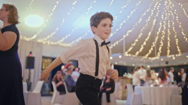 Dance, music and fun for child at wedding, young boy enjoying the party. Dancing the night away in celebration of love, disco and a favorite song. Friends, family and a dj, kids energy at reception
