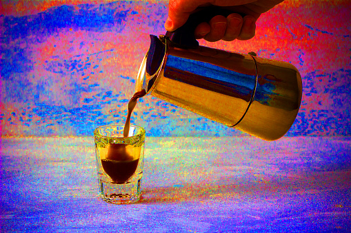 Filling a coffee in a glass shot out of geyser coffee maker, toned colorful photo in impressionism style
