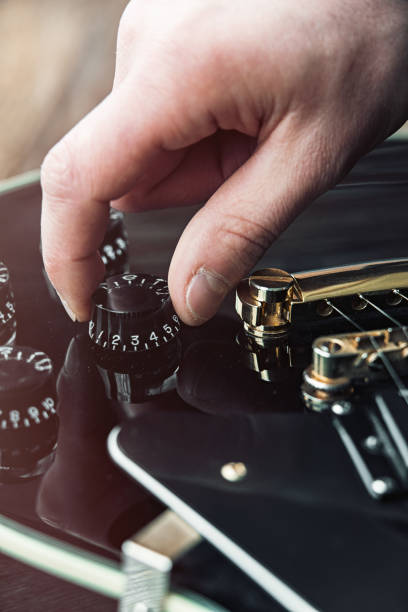 istock Male hand changing electric guitar settings. Tuning a timbre regulator 1430001019