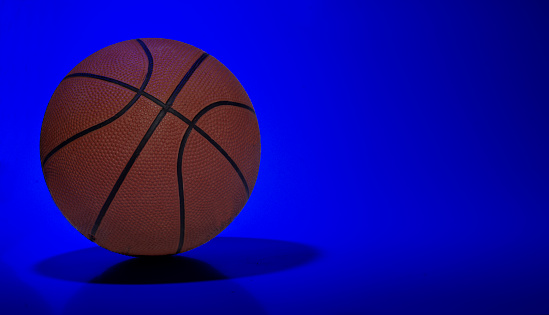 Basket ball on blue light abstract background with copy space.