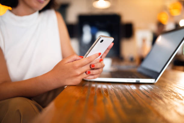 istock Unrecognizable businesswoman using mobile phone while working at the coffee shop 1430001903