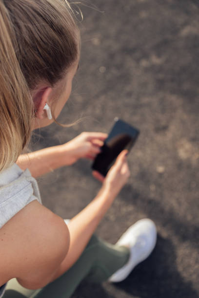 istock Caucasian athlete resting between sets and looking at phone while listening to music. 1430002339