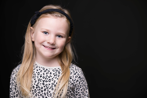 Studio shot of a cute girl of five wearing black and white.