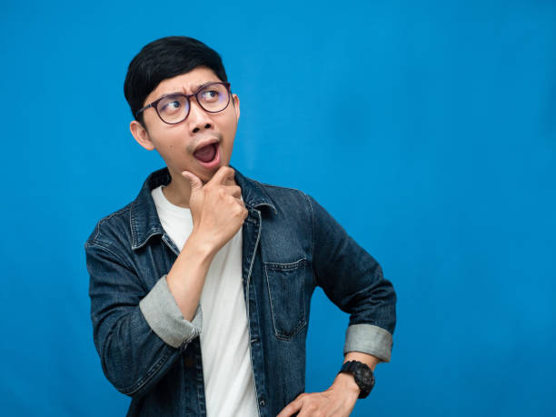 istock Young man jeans shirt feels amazed looking at copy space blue background 1430007445