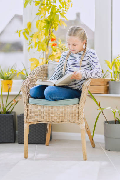 istock Eight-year-old girl reading in the conservatory 1430009771