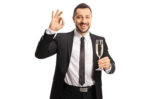 Businessman holding a glass of champagne and gesturing good sign isolated on white background
