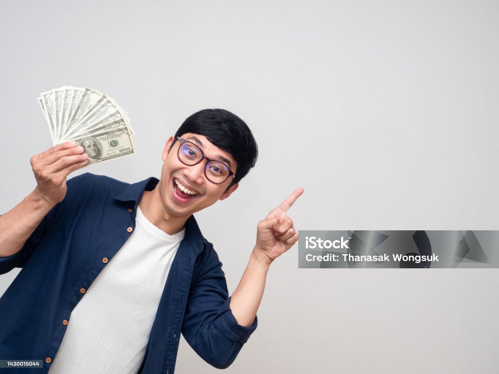 Positive asian man holding money smile gesture point finger isolated Men Stock Photo