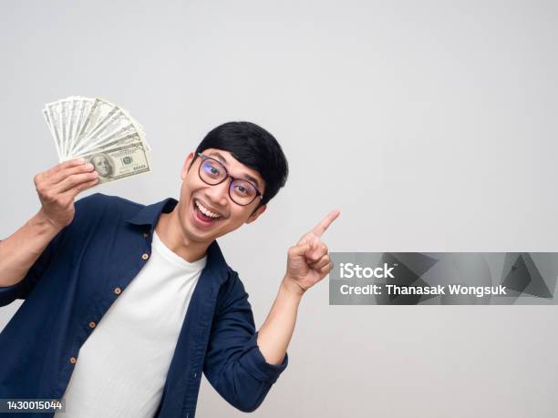 Positive Asian Man Holding Money Smile Gesture Point Finger Isolated Stock Photo - Download Image Now