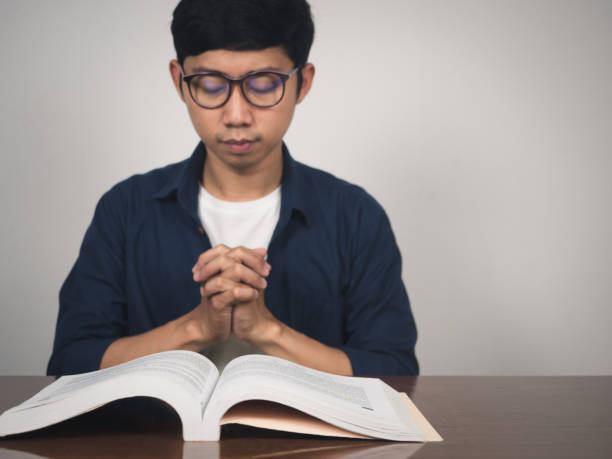 istock Asian man wear glasses joy hands wish to pass testing at table 1430015584
