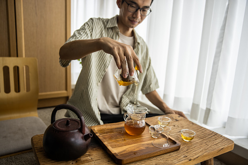 Asian man making Chinese tea at home