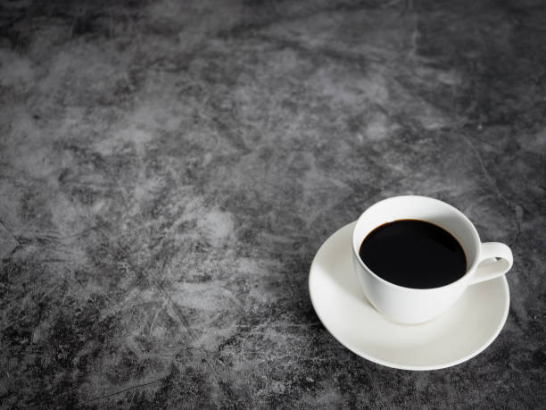 istock Black coffee white cup on dark floor table copy space 1430019515