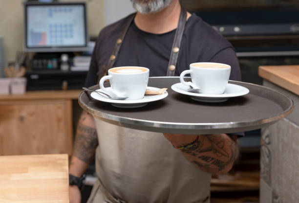 istock a waiter working in a coffee shop or bar holding a tray with coffees 1430024629
