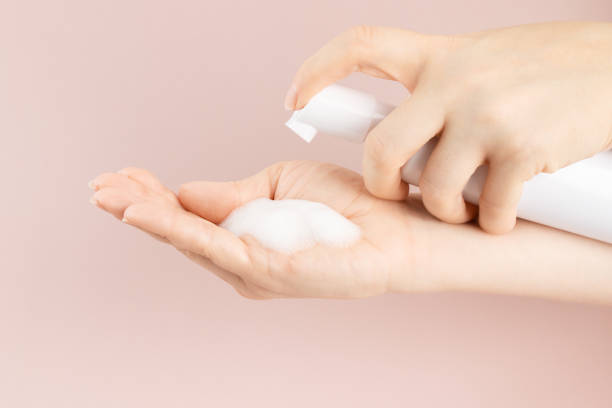istock Cosmetics foam pump container, facewash dispenser in a woman's hand 1430034547