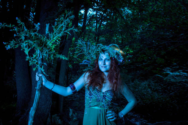 Redhead beautiful lady in green dress posing in the forest