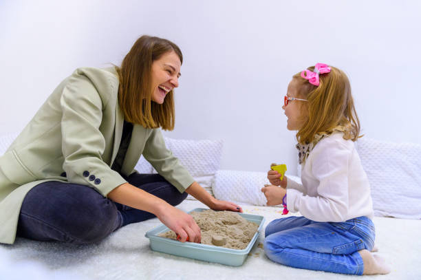 Young girl and her therapist interacting during occupational therapy. Child therapy background. Young girl and her therapist interacting during occupational therapy. Child therapy background. sensory impulse stock pictures, royalty-free photos & images