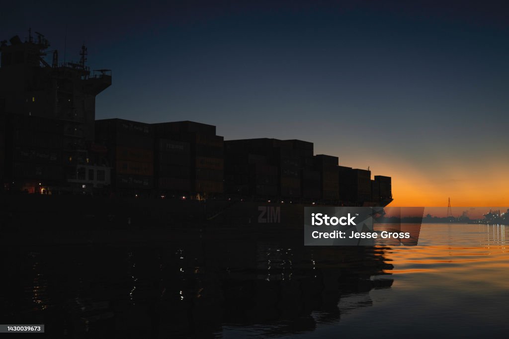Cargo Ship at Sunset Cargo ship leaving port in Savannah, GA Beauty In Nature Stock Photo