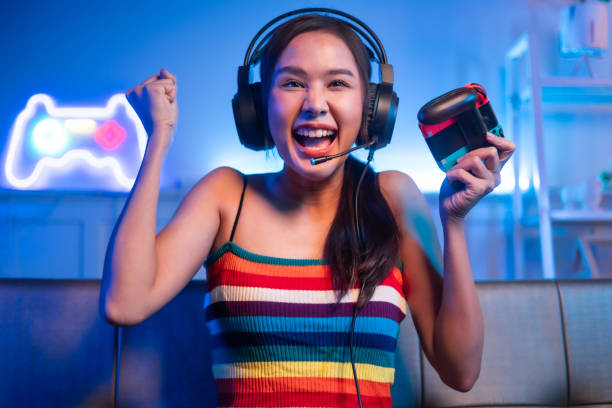 istock Young asian woman is using virtual reality headset. Neon light studio portrait. Concept of virtual reality, simulation, gaming and future technology.Asian woman play game in living room. 1430039803