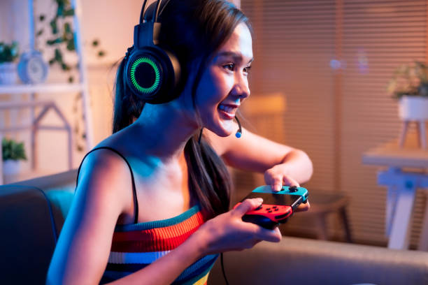 istock Young asian woman is using virtual reality headset. Neon light studio portrait. Concept of virtual reality, simulation, gaming and future technology.Asian woman play game in living room. 1430039867