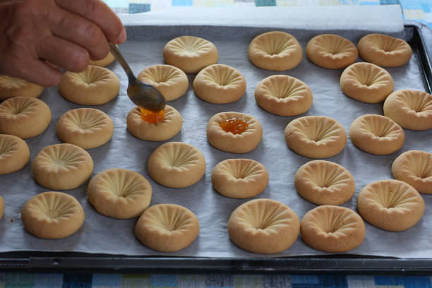 istock hand with table spoon putting orange jam on cookies 1430042575