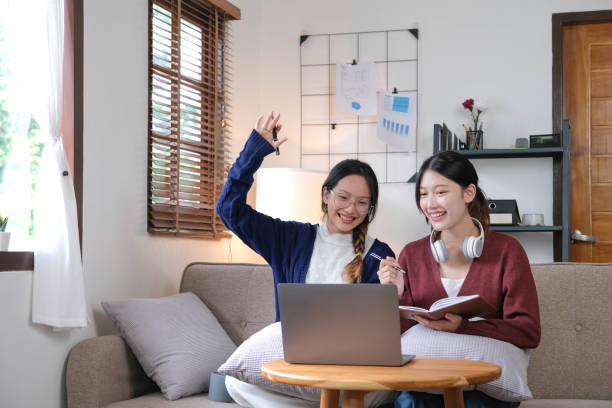 istock Two asian students learning together online with a laptop and tutor together at home. 1430045973