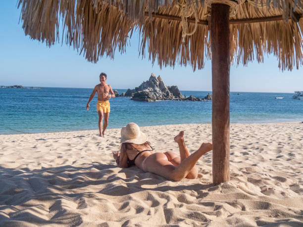 istock Multiracial couple sunbathing on the beach in Mexico 1430046628