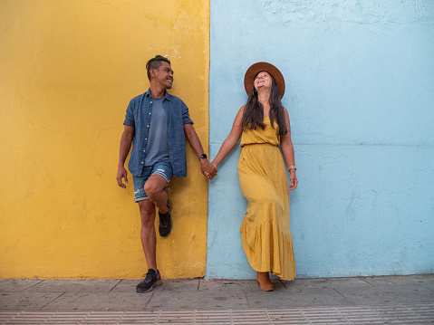 They pose in front of a blue and yellow wall