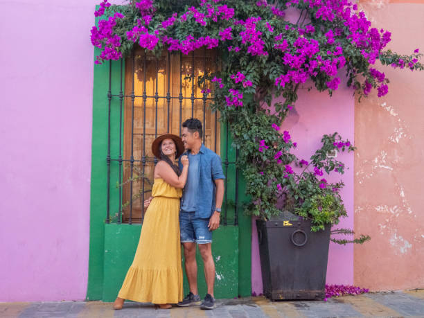istock Multiracial couple traveling in Mexico and posing under a bougainvillea tree 1430047607