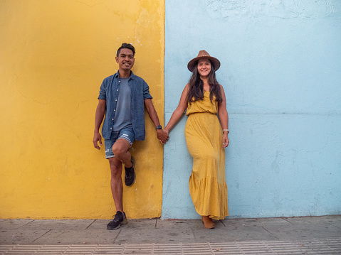They pose in front of a blue and yellow wall