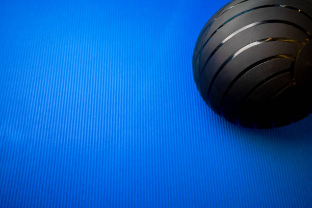istock Black fitness ball on blue mat backgorund 1430049372