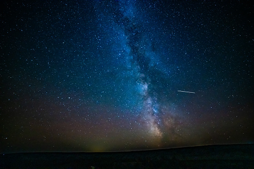 Milky Way and shooting star in night sky over the Missouri River in the Charles M Lewis Wildlife Refuge in northern Montana, western USA.