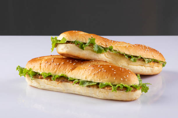 вкусный сэндвич с багетом с различными овощами и ломтиками сыра, помещенный на белый фон в студии - sandwich delicatessen bacon lettuce and tomato mayonnaise стоковые фото и изображения