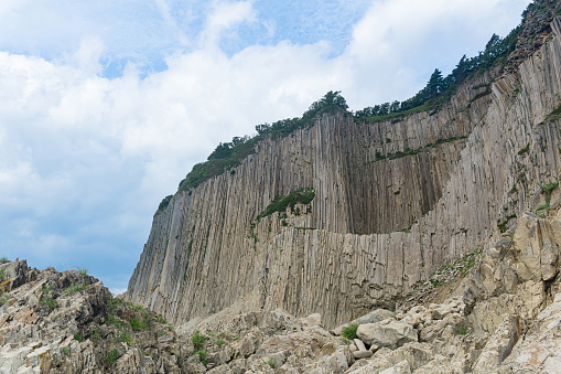 high coastal cliff formed by solidified lava stone columns, Cape Stolbchaty on Kunashir island
