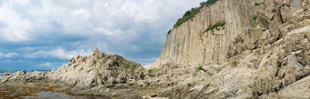 istock panorama with coastal cliff formed by solidified lava stone columns, Cape Stolbchaty on Kunashir island 1430054601