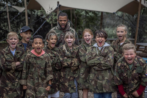 Male caretaker with a group of children during a paintball activity Black male caretaker with a group of children during a paintball activity paintball photography stock pictures, royalty-free photos & images