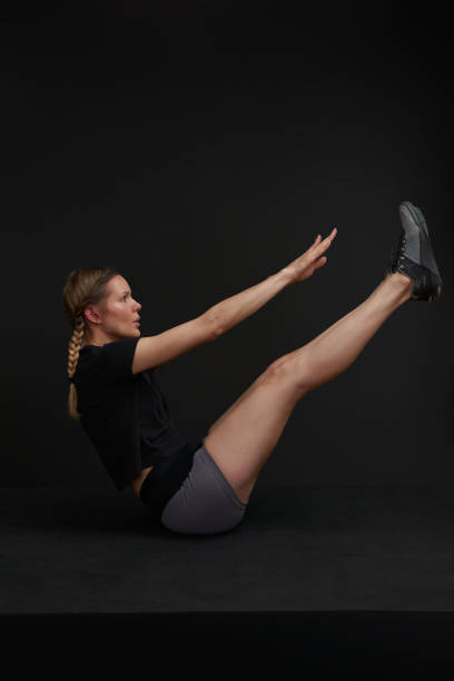 istock Female athlete demos exercise movements on black background 1430056790