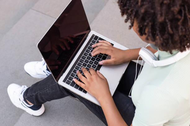 istock College student sitting on the stairs working on a laptop. 1430062009